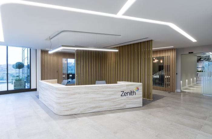 Modern office reception with Zenith branded desk and linear LED ceiling lighting
