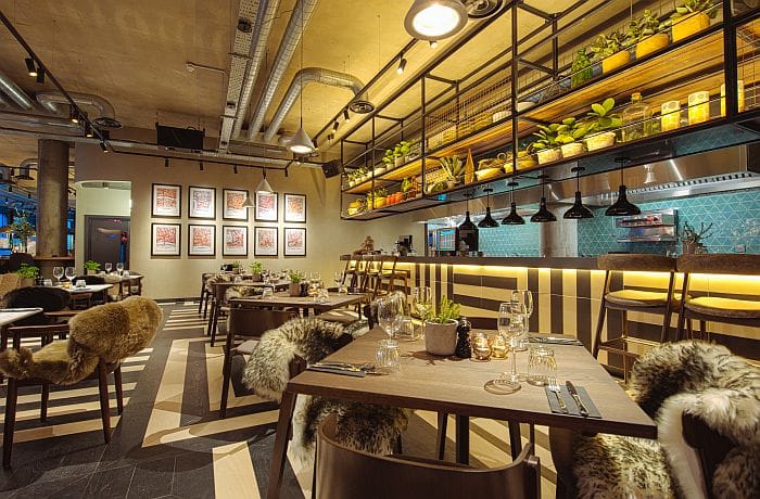 Hanging light fixtures and warm shelf lighting create an intimate restaurant atmosphere.